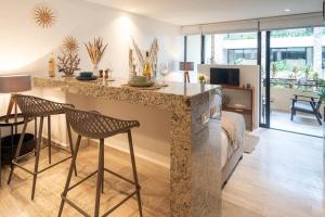a kitchen and living room with a counter and chairs at Syrena Multi Listing in Playa del Carmen +22 photos