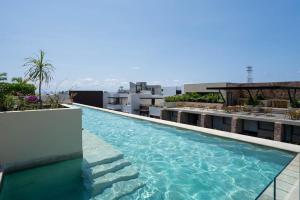 a swimming pool on the roof of a building at Syrena Multi Listing in Playa del Carmen