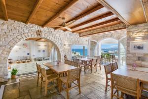 eine Küche mit Holzdecke, Tischen und Stühlen in der Unterkunft Paliomylos Spa Hotel in Naoussa