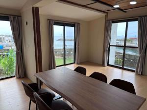a conference room with a table and chairs and windows at 勝浦の家 in Katsuura