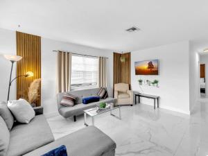 a living room with a couch and a table at Casa Playa Coastal Comfort 10 Min From Beach in Hallandale Beach