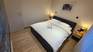 a bedroom with a bed with two shoes on it at Villa Jelena Rooms and Apartments in Kovačić