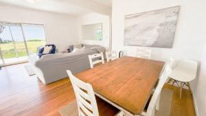 a dining room with a table and a bed at On The Beach in Wooli