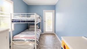a bedroom with bunk beds in a room with blue walls at The Blue Groper in Minnie Water