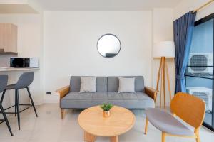 a living room with a couch and a table at Aster Canopy Suites & Living in Rayong
