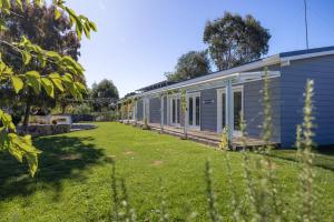 a blue house with a yard next to it at Edelweiss Cottage in Berridale +28 photos