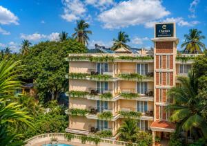 an apartment building with a sign on top of it at Clarion Hotel Ocean Palms Goa in Calangute