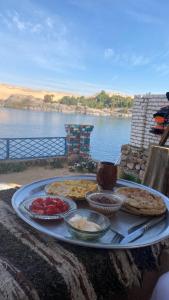 a tray of food on a table next to the water at Hooly Nubian in Aswan
