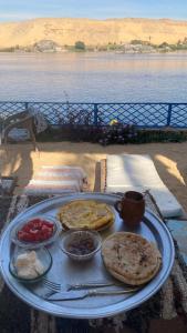 a tray of food on a table next to the water at Hooly Nubian in Aswan +59 photos