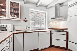 a kitchen with white cabinets and a window at 0194-Romo-Rabjergvej-76 in Høm