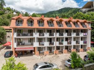 an apartment building with cars parked in front of it at Hotel Iveria in Abastumani