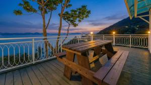 a wooden bench sitting on a deck overlooking the water at Namhae baramundeok Pension in Namhae +3 photos