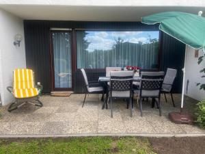 a patio with a table and chairs and an umbrella at Ferienwohnung Fein in Bad Sachsa