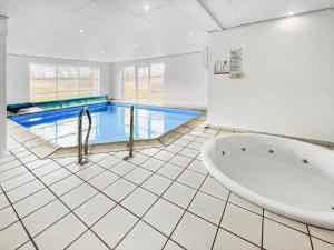 a large bathroom with a tub and a swimming pool at 0045-Romo-Thadesvej-13 in Høm