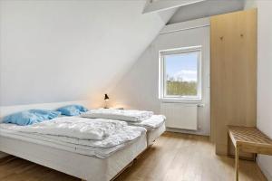 a white bedroom with a bed and a window at 0045-Romo-Thadesvej-13 in Høm +14 photos