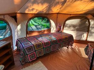 a tent with a bed in it with two windows at Glamping Tent Tammemäe in Haapsi +6 photos