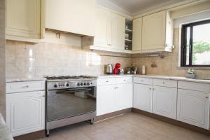 a kitchen with white cabinets and a stove top oven at Fernando Pessoa Villa in Faro