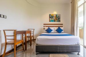 a bedroom with a bed and a desk and a table at Fisherman's Cove in Wattala