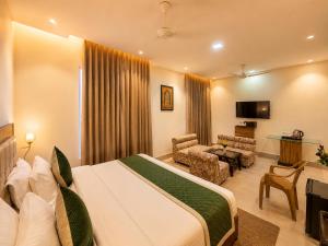 a hotel room with a bed and a living room at HOTEL LUXURY KASHI VISHWANATH- VARANASi in Varanasi