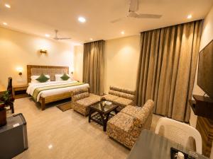 a hotel room with a bed and a table and chairs at HOTEL LUXURY KASHI VISHWANATH- VARANASi in Varanasi +20 photos