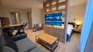a living room with a couch and a bed and a television at Villa Jelena Rooms and Apartments in Kovačić