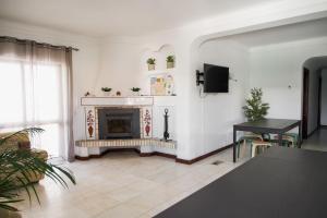 a living room with a fireplace and a table at Fernando Pessoa Villa in Faro