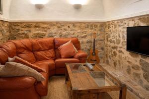 a living room with a brown leather couch and a table at Casa de la Suerte in Benissa