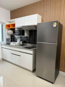 にあるHouse99のステンレス製の冷蔵庫と白いキャビネットを備えたキッチン