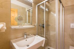 une salle de bain avec lavabo et douche dans l'établissement Hotel Traube, à Bressanone 26 autres photos