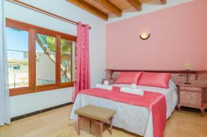 a bedroom with a bed with red pillows and a window at Can Pedro Ros in S'Illot