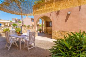 a table and chairs sitting under an umbrella on a patio at Can Pedro Ros in S'Illot