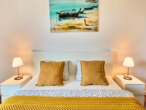 a bedroom with a bed with yellow sheets and two lamps at Ursus Premium Apartments in Warsaw