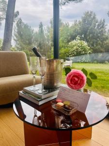a coffee table with wine glasses and a rose on it at Haras de Castellane in Pertuis