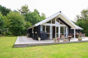 a black and white cottage with a deck at 11866-Nykobing-Sj-Skippervej-17 in Nyrup