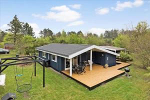 a small blue house with a wooden deck at 13373-Asnaes-Radyrvej-24 in Asnæs
