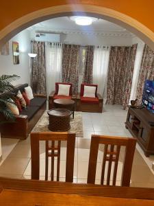 a living room with a couch and a table and chairs at LANISCA'S Home in Yaoundé