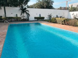 a swimming pool with blue water in front of a building at Tcc - Skysuites in Accra