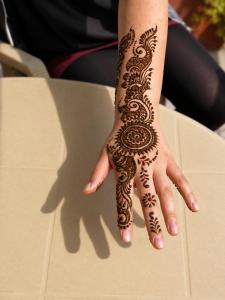 a woman with a henna design on her hand at Smyle Inn - Comfort & Value near New Delhi Railway Station - since 1998 in New Delhi