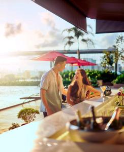 a man and a woman standing at a table at a restaurant at Amari Kuala Lumpur in Kuala Lumpur