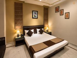a bedroom with a bed with two night stands and two lamps at Smyle Inn - Comfort & Value near New Delhi Railway Station - since 1998 in New Delhi