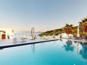 a large swimming pool with chairs and the ocean at Casa Mare Bodrum in Bodrum City