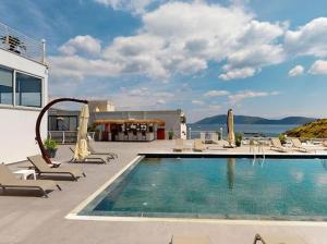a swimming pool with lounge chairs next to a building at Casa Mare Bodrum in Bodrum City