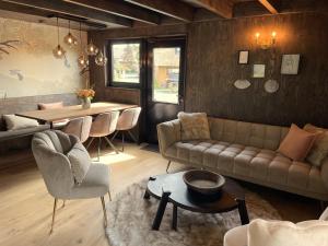 a living room with a couch and a table at Park Heerehof Schoorl in Schoorl