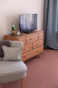 a television sitting on top of a wooden dresser at Hotel Zur Post in Roßbach +6 photos