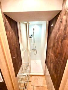 a bathroom with a walk in shower and a laundry basket at Rhodes Kagurazaka in Tokyo