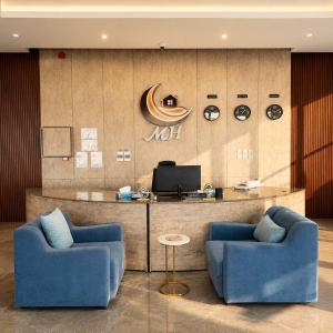 a lobby with two blue chairs and a counter at moon havena مون هافينا in Dhahran +6 photos