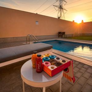 a box of donuts and drinks on a table next to a pool at moon havena مون هافينا in Dhahran