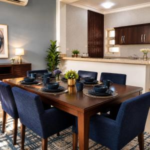 a dining room table with blue chairs around it at moon havena مون هافينا in Dhahran