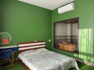 a green bedroom with a bed and a large mirror at She Stay in Hòa Bình