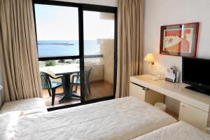 a hotel room with a bed and a view of the ocean at AR Almerimar in Almerimar +55 photos